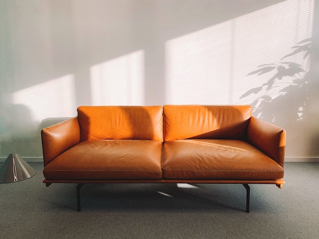 a light brown leather sofa in a grey room